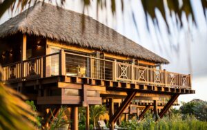 Wooden beachfront structure glowing in golden hour light, set against a tropical seaside backdro