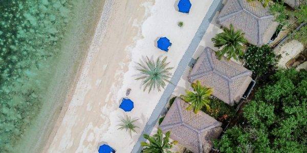 Aerial view of Labuan Bajo coastline with Touchwood wooden villas overlooking the sea