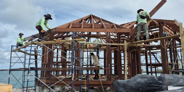 Beachfront bungalow under construction using natural Merbau wood on a tropical shoreline.