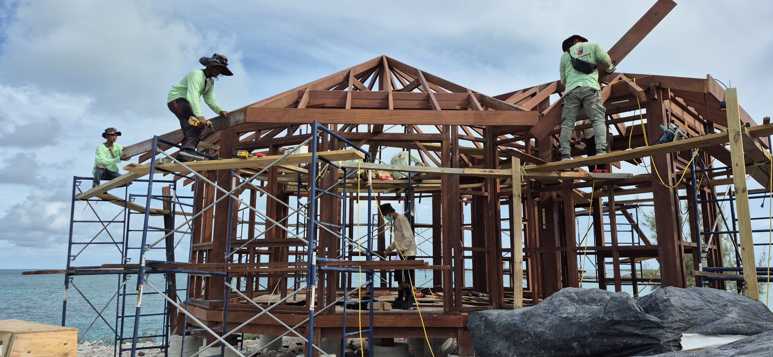 Beachfront bungalow under construction using natural Merbau wood on a tropical shoreline.
