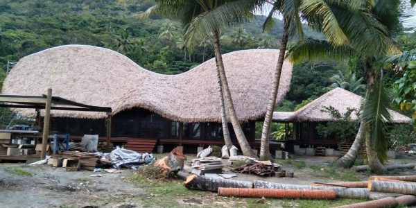 Ongoing construction of tropical wooden villa by Touchwood in Fiji featuring curved CLT roof and hardwood structure.